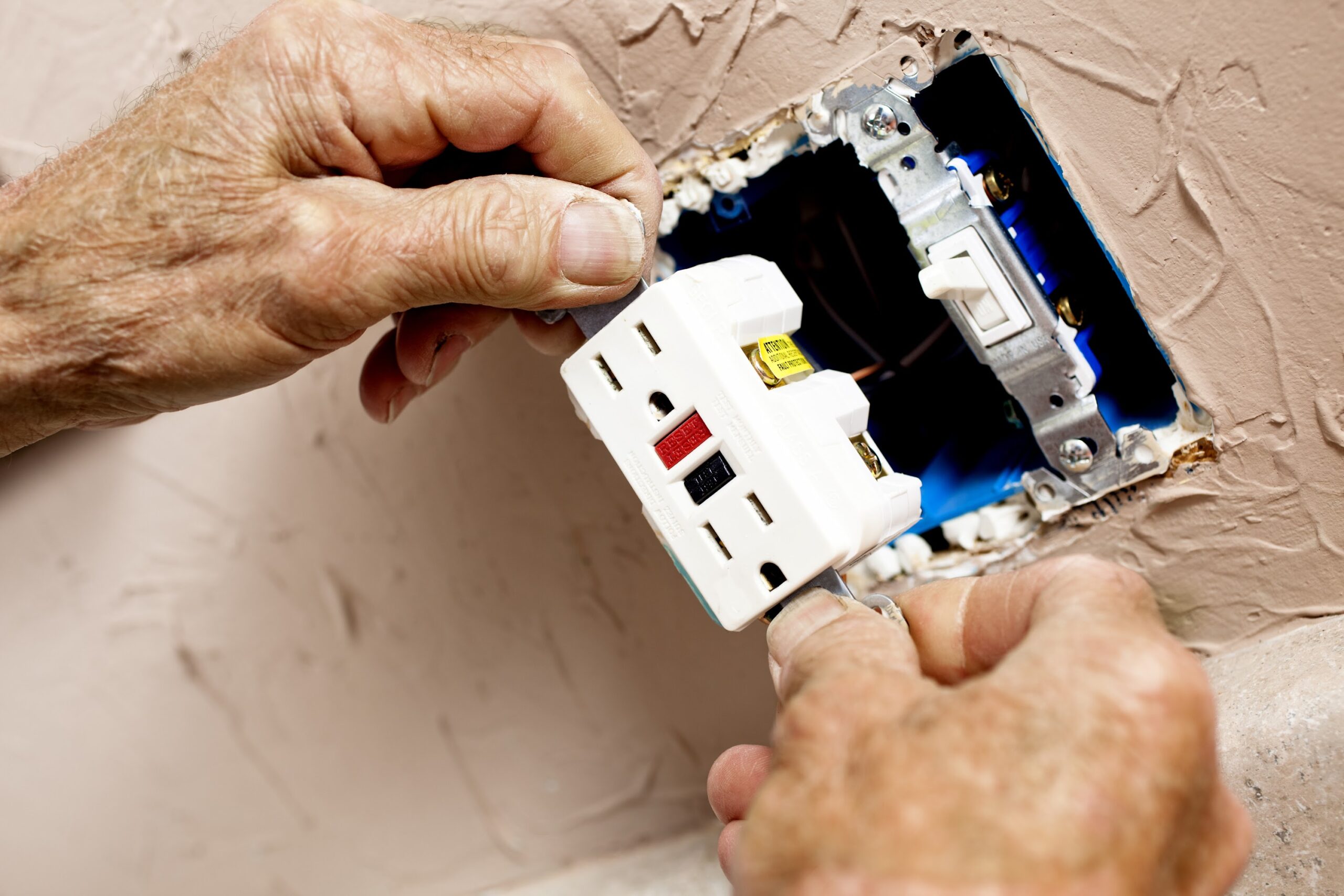 Electrician installing GFI plug in kitchen