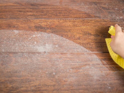Wiping dusty wood using yellow rag